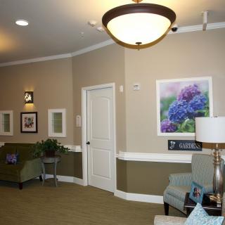 A cozy waiting room with comfortable seating, artwork on the walls, and soft lighting.