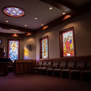 A serene church interior featuring stained glass windows and seating.