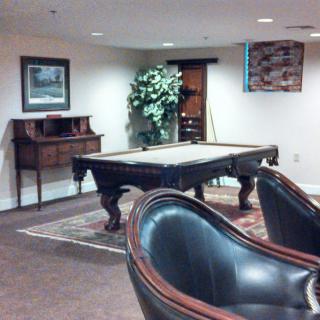 A cozy game room with a pool table and comfortable seating.