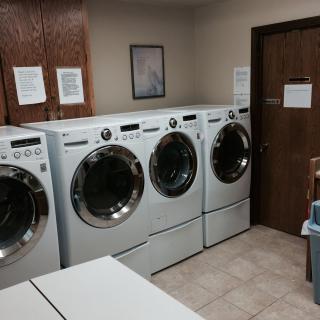 A laundry room featuring multiple washing machines in a neat row.