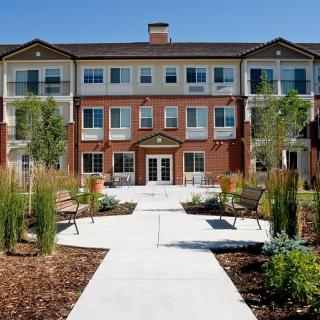 A modern residential apartment building with surrounding landscaped gardens.