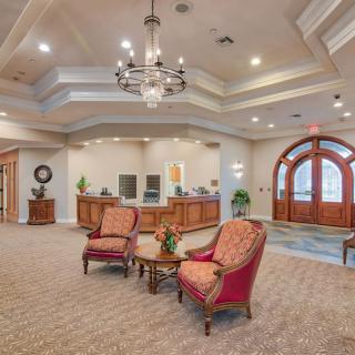 A spacious lobby with elegant furnishings and a chandelier.