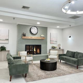 A stylish and modern living room with green sofas, a coffee table, and tasteful decor.