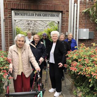 A joyful group of seniors enjoying their time outdoors at a care facility.