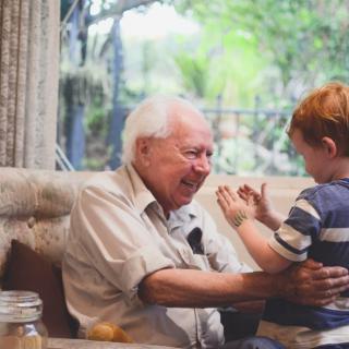 A joyful moment between a grandparent and their grandchild indoors.