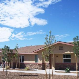 A suburban residential house with a landscaped front yard under a clear blue sky.