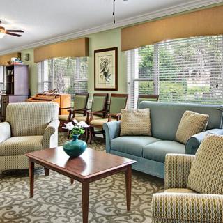 A cozy living room with comfortable seating and natural light from large windows.