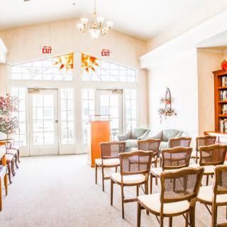 A bright and inviting lecture room with a seating arrangement, podium, and large windows letting in natural light.