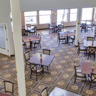 An empty dining room with several tables and chairs arranged neatly.