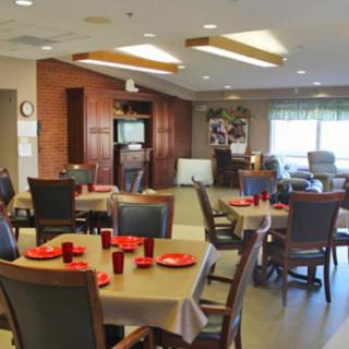 A well-lit dining area with tables and chairs arranged for communal gatherings.