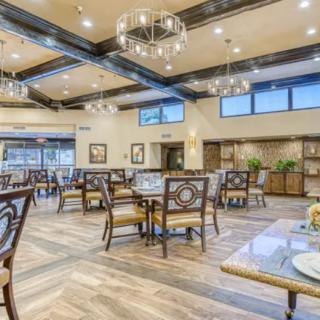 An elegant restaurant dining room featuring chandeliers and wooden furniture.