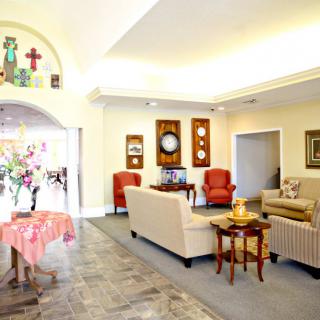 A cozy living room with sofas, armchairs, and decorative wall art.