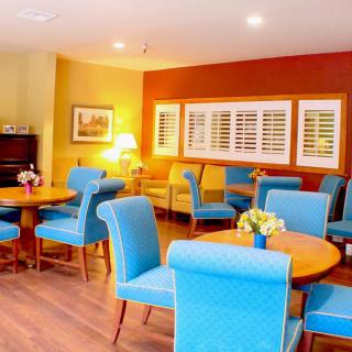 A brightly colored dining area with blue chairs and wooden tables, featuring a cozy ambiance.