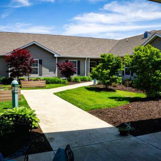 A well-maintained garden with a pathway leading to a house on a sunny day.