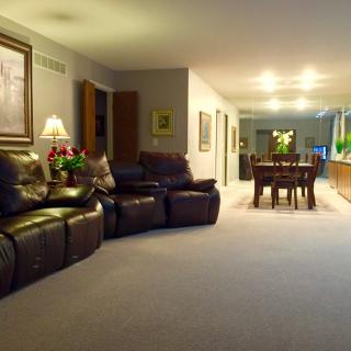 A cozy living room with reclining sofas and a dining area in an open-plan space.