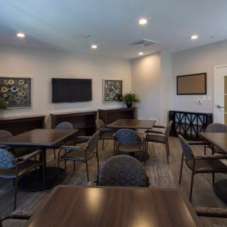 A modern conference room with tables and chairs arranged for meetings.