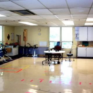 An empty classroom with tables and chairs.
