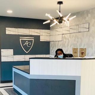 A modern reception area with a person sitting behind the desk.