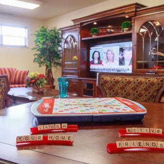 A cozy living room setup with a Scrabble game ready to play and a television in the background.