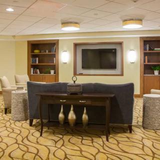 Modern lobby seating area with a TV and bookshelves.