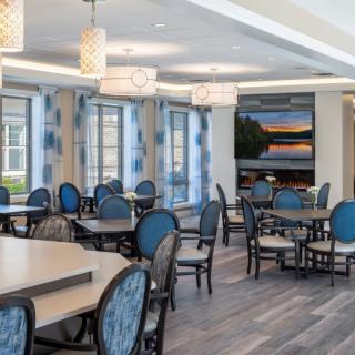 A modern dining area with blue chairs and elegant lighting.