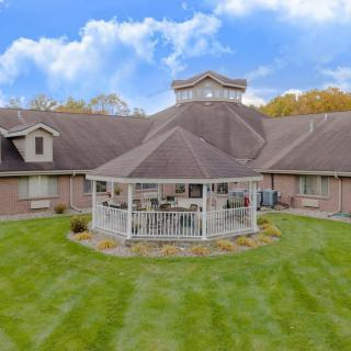 A large house with a central gazebo surrounded by a well-maintained lawn.