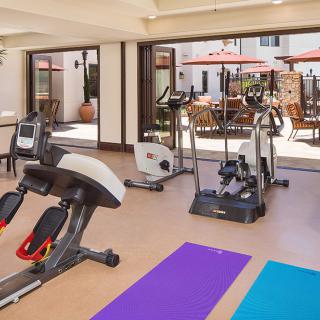 A well-equipped gym with exercise machines and yoga mats.