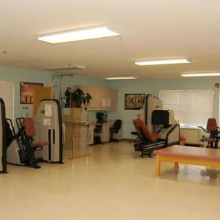 An empty rehabilitation and exercise room with various fitness equipment.