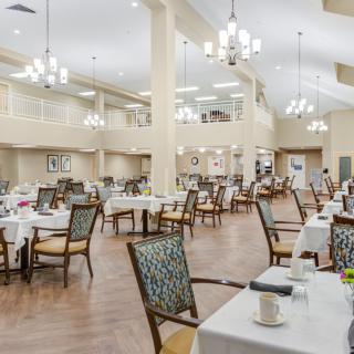 A spacious and elegantly designed dining area with neatly arranged tables and chairs.