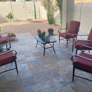 A cozy outdoor patio space featuring comfortable chairs and a small table, perfect for relaxation.