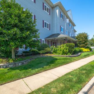 A well-maintained residential building with a landscaped garden and sidewalk.