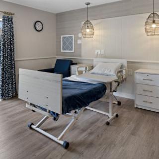 A clean and modern hospital room with a patient bed and medical equipment.