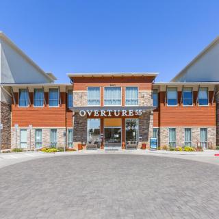 A commercial building with a prominent entrance and signage reading 'OVERTURE', featuring modern architecture.