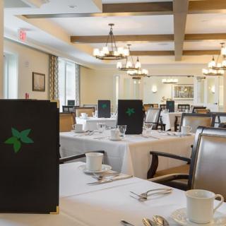 A well-lit restaurant dining room with neatly set tables, chairs, and menus.
