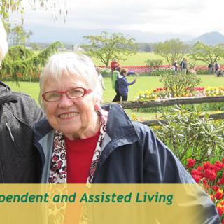An elderly woman enjoying a day outside in a garden, surrounded by flowers, promoting independent and assisted living.