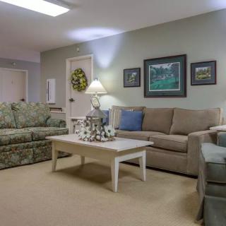 A cozy living room with sofas, a coffee table, and wall art.