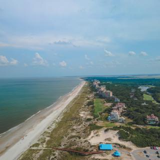 Aerial view of a coastal resort lined with buildings along the beach.