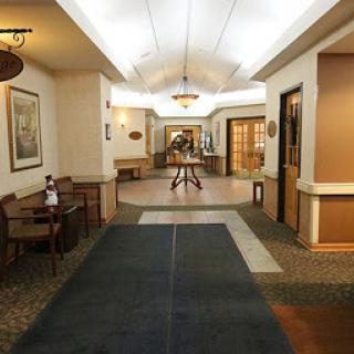 A well-lit and elegantly designed hotel lobby corridor with comfortable seating.