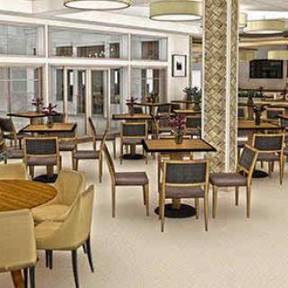 A modern cafe interior featuring several tables and chairs arranged neatly.