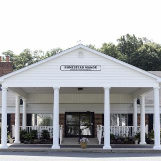 A building with a columned entrance and white facade.