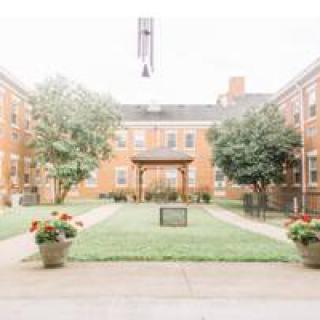 A serene courtyard surrounded by brick buildings and greenery.
