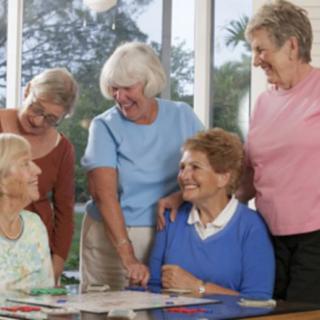 A group of seniors happily engaging in conversation indoors.