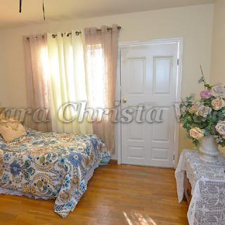 A cozy bedroom with a single bed and floral decor.