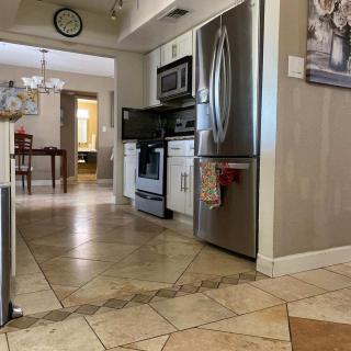 A modern kitchen with tiled flooring, stainless steel appliances, and neutral interior decor.