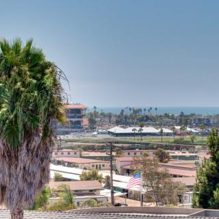 A scenic view of an urban area with palm trees and buildings in the distance.