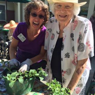 Two women enjoying gardening outdoors together.
