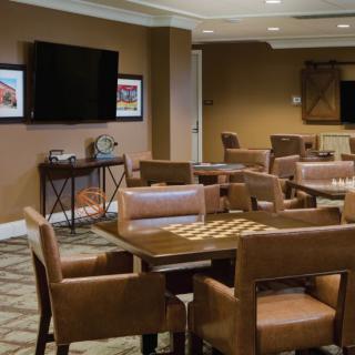 A well-appointed lounge featuring comfortable seating and a large television for meetings or leisure.