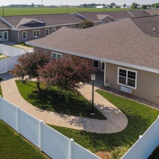A suburban house with a fenced yard and landscaped pathway.