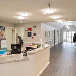 A modern office reception area with a desk and hallway.
