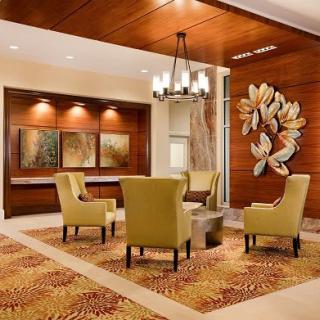 A modern lobby with comfortable seating, decorative artwork, and a stylish chandelier.